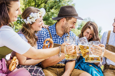 Junge Leute stoßen gemeinsam mit einem Maß Bier an
