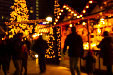 Besinnliche Atmosphäre am Bergadvent: verschwollemes Bild von Personen vor einem Stand